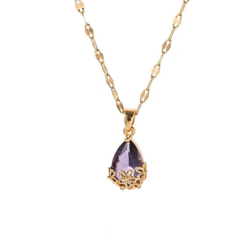 Collar largo con dije de gota de agua en piedra morada montado en flores metálicas