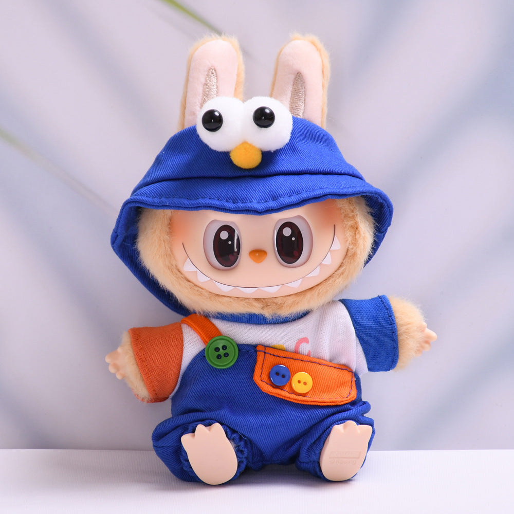 Conjunto azul para muñeco tipo Labubu con gorro de ojos grandes y peto con botones. Inspirado en personajes de Plaza Sésamo.