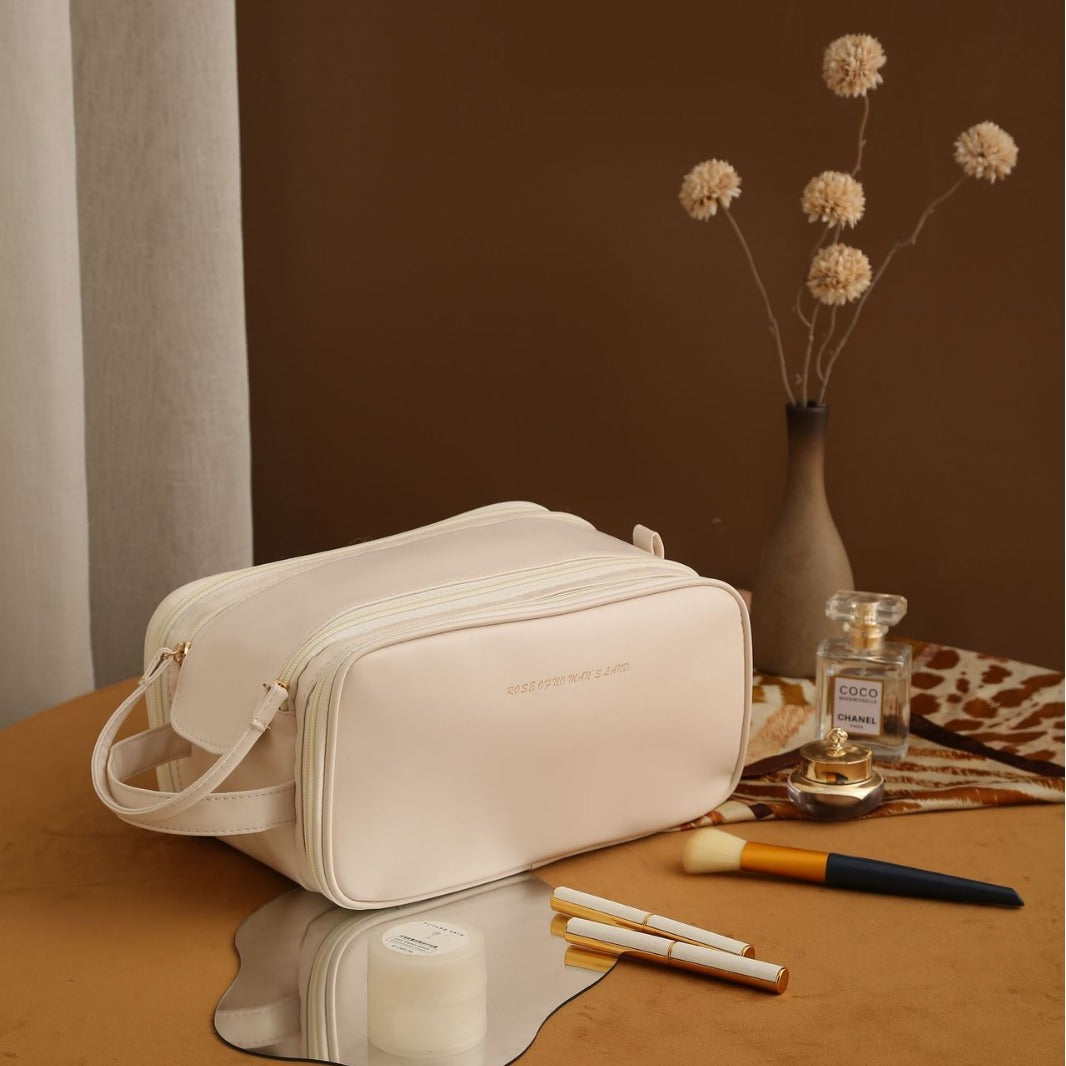 Neceser de maquillaje portátil de PU en color crema con doble cremallera, perfecto para organizar cosméticos en viajes.