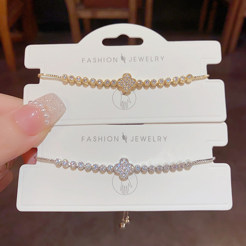 Pulsera con trébol de cuatro hojas, zirconias brillantes y cierre deslizable con borlas