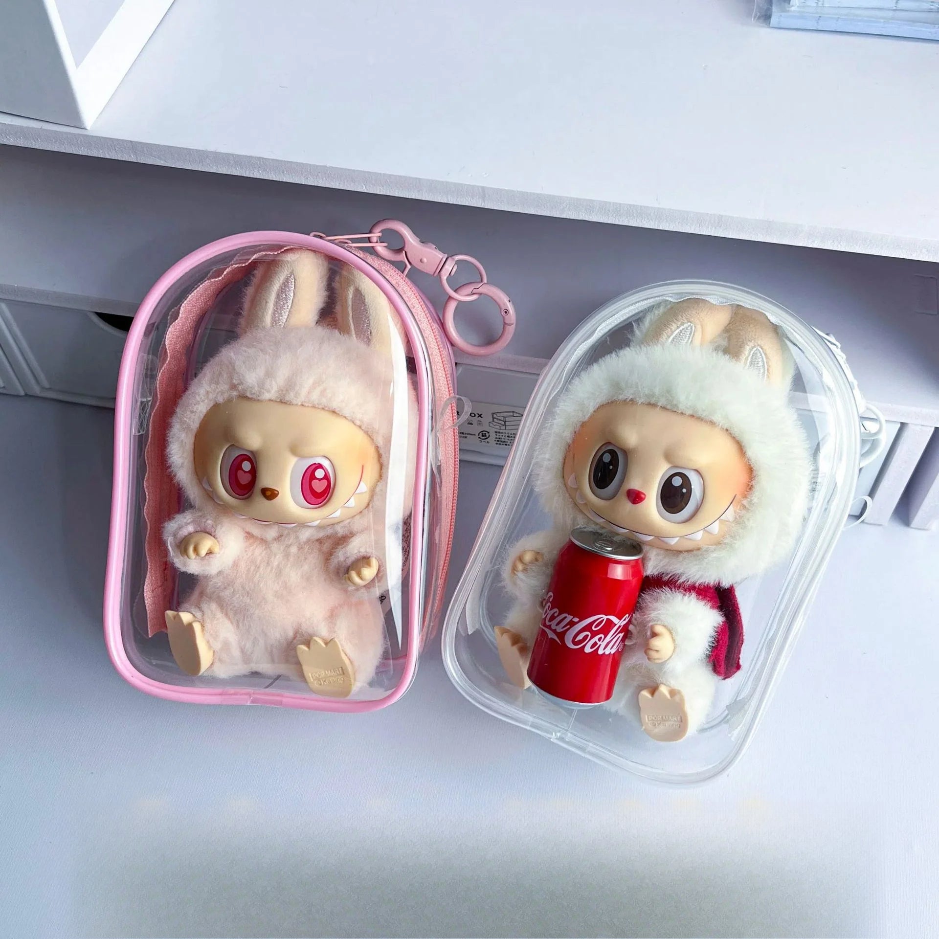 Bolsa protectora transparente para Labubu Have a Seat de 15 cm en rosa y transparente, ideal para proteger figuras de peluche del polvo.